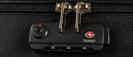 Close-up of a TSA-approved three-digit combination lock on premium luggage with the dials set to 000.